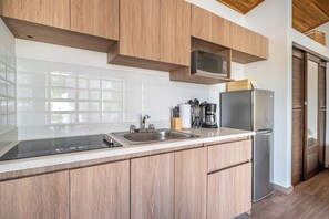 A modern kitchen with wooden cabinets, a stainless steel sink, a microwave, and a refrigerator. - Studio w/ Shared Pool < 1 Mi to Playas Del Coco! (Playas del Coco)