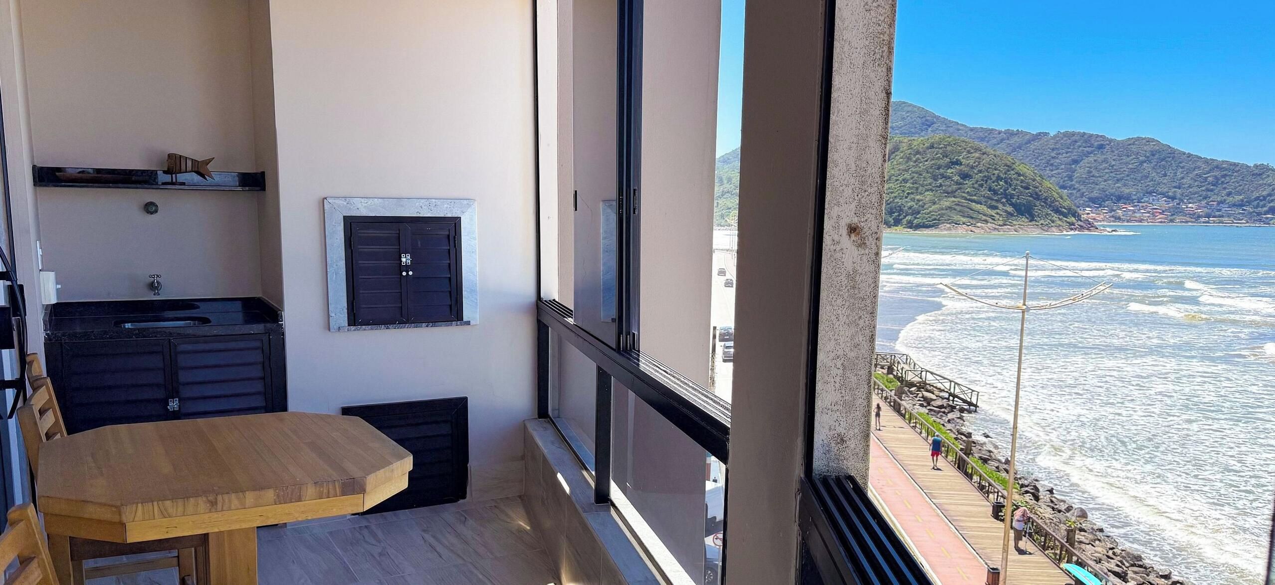 A balcony with a wooden table and a small kitchenette.