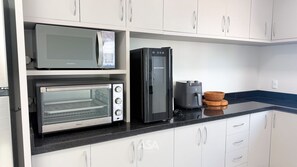 A kitchen with a microwave, toaster oven, and refrigerator. - ASA Vista Mar 3QT Alto Padrao Itapema (Itapema)