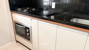Eine Küche mit Herd, Backofen und Geschirrgestell.