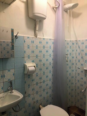 A bathroom with a toilet, sink, and shower. - Cozy, fully equipped, and quiet outbuilding 300m from USP in Vila Butantã (São Paulo)