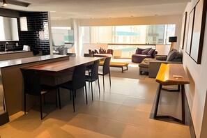 Une cuisine moderne avec un coin repas, un canapé et une table basse.