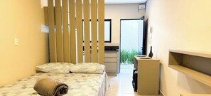 A compact hotel room with a bed, a desk, and a kitchenette. - ASA Smart Living Studio Downtown Balneario Camboriu (Balneário Camboriú)