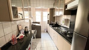 Eine Küche mit schwarzer Arbeitsplatte, Edelstahlgeräten und beigen Schränken.