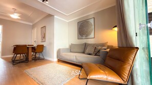 Ein Wohnzimmer mit einer Couch, einem Couchtisch und einem Essbereich mit Stühlen.