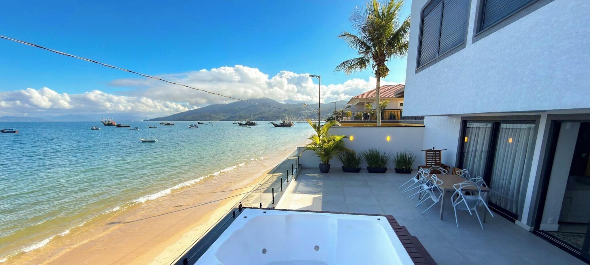 Ein Balkon mit Meerblick, einem Whirlpool und Sitzgelegenheiten im Freien.