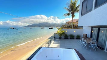 Ein Balkon mit Meerblick, einem Whirlpool und Sitzgelegenheiten im Freien.