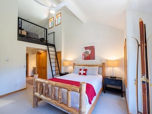 A bedroom with a wooden bed, a ladder, a desk, a chair, a ski rack, and a window with blinds. - Crystal Ridge | Stunning Views, Private Hot Tub, & Walk to Gondola/Village Core (Mountain Village)