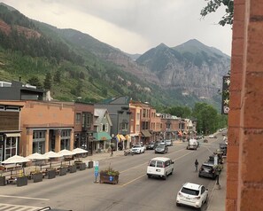 A street with buildings, cars, and mountains in the background. - Main Street Luxury in Heart of Telluride | Walk to Gondola and Explore Town (Telluride)