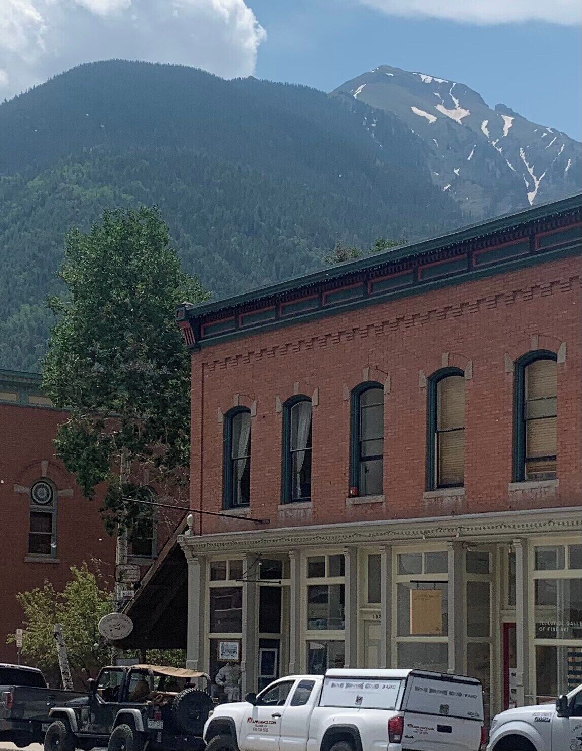 A brick building with a mountain in the background.