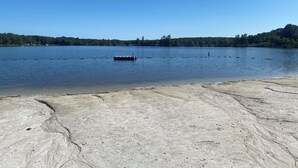 Un lago con orilla de hormigón y un muelle que se adentra en el agua.