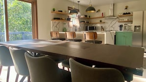Una cocina moderna con comedor, ventanas amplias y un balcón.