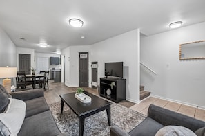 A modern living room with a sofa set, a coffee table, and a TV.