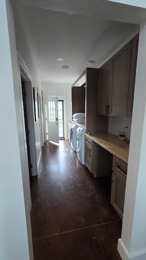 A laundry area with a washing machine, dryer, and cabinets.