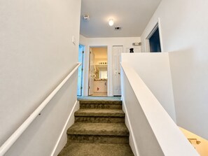A carpeted staircase with white handrails leading to a doorway. - 20 Min to Disney World | 4BR Pool Home (Kissimmee)