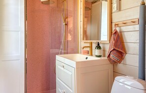 A bathroom with a shower, a sink with a soap dispenser, and a towel hanging on a rack. - Gorgeous home in Roslev with house a panoramic view (Roslev)