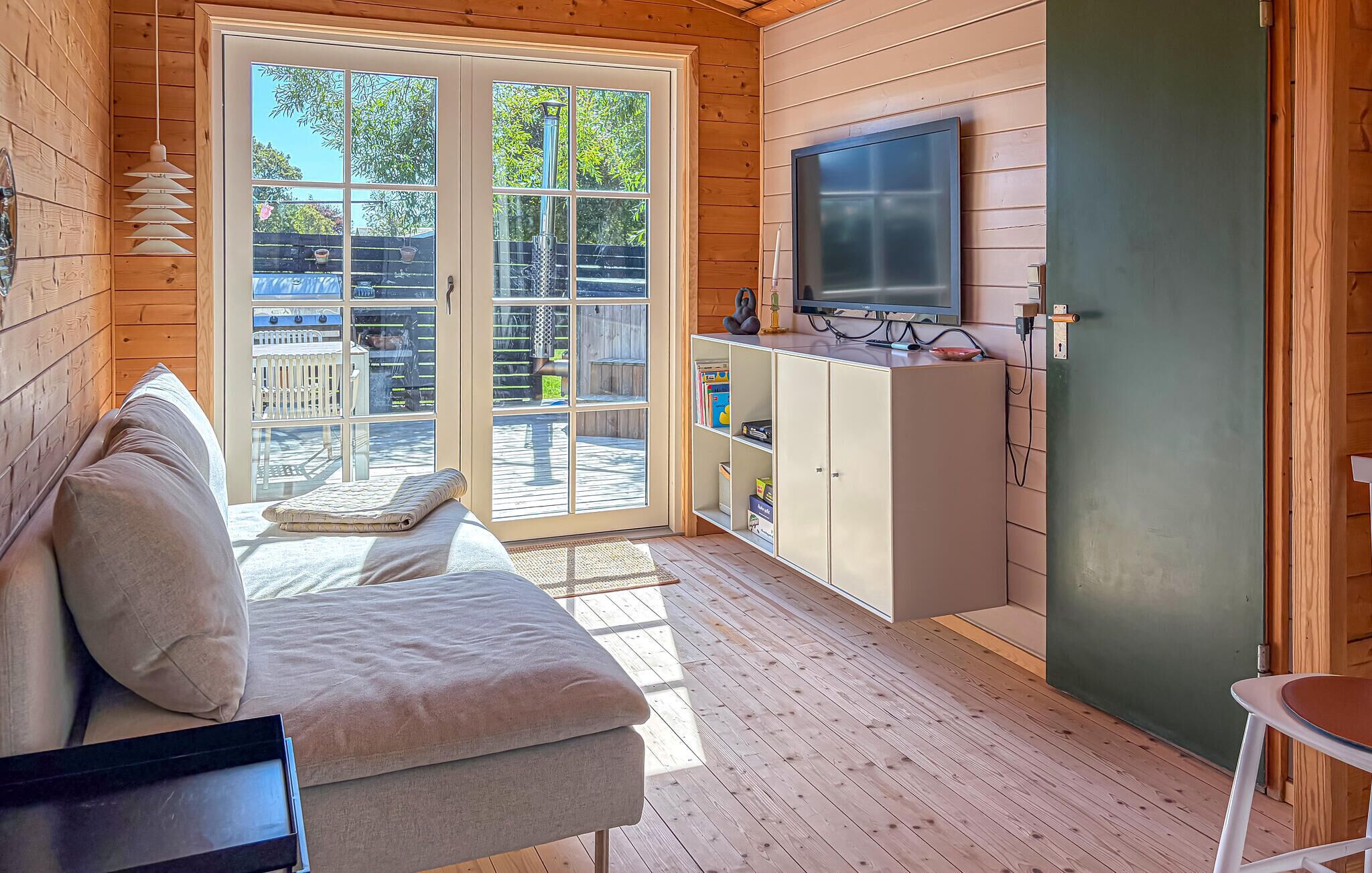 A cozy room with a sofa, a television, and a cabinet.