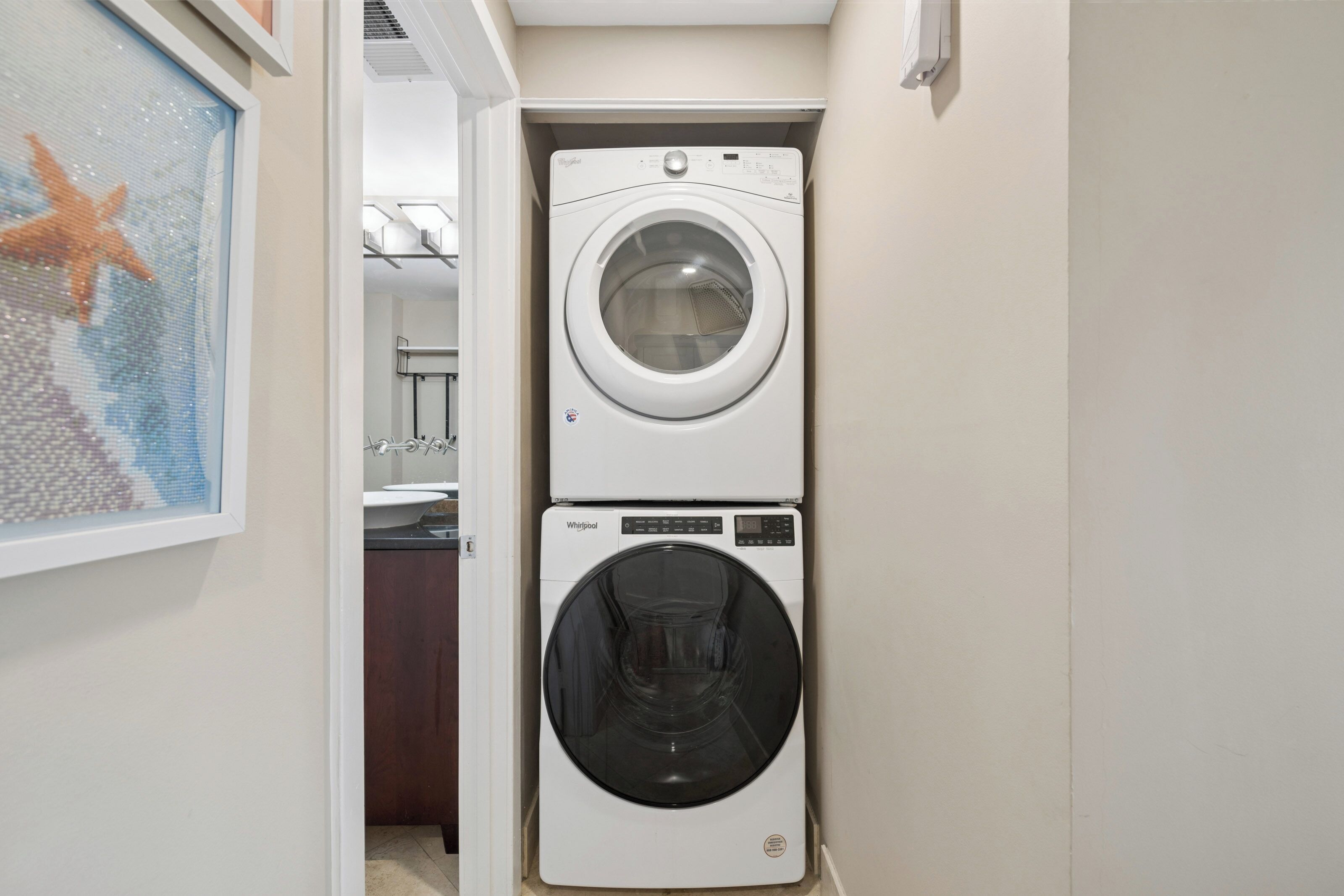 A compact laundry area with a top-loading washer and a front-loading dryer.