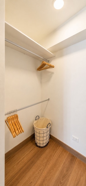A laundry room with a wooden floor, a metal drying rack, a wooden clothes rack, and a laundry basket. - Suite ejecutiva Piscina y Gym San Isidro (San Isidro)