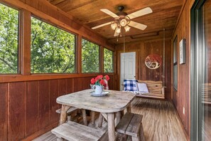A wooden cabin with a round wooden table and benches, a ceiling fan, and a hanging swing chair. - Incredible 3 Level Luxury Cabin! 4 Bedroom Suites, 2 Living Areas, 3 Pools-21 (Branson)