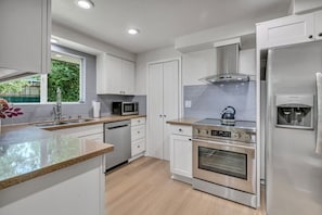 A modern kitchen with stainless steel appliances, a built-in oven, and a water dispenser. - Three bedroom  in United States of America, Kent (Kent)