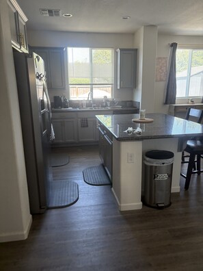 A kitchen with a central island, stainless steel appliances, and a trash can. - Beautiful 4-bedroom house with RV parking and pet-friendly. Located in Williams. (Williams)