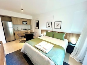 Ein Hotelzimmer mit einem Bett, einem Schreibtisch, einem Stuhl, einer Mikrowelle und einem Kühlschrank.