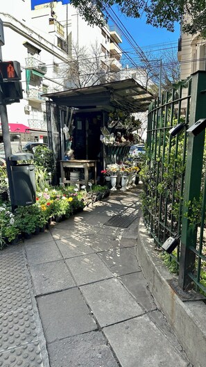 A narrow pathway with potted plants and a small structure, possibly a kiosk or shop, with a metal fence on one side. - The Ultimate Studio in Palermo (Buenos Aires)