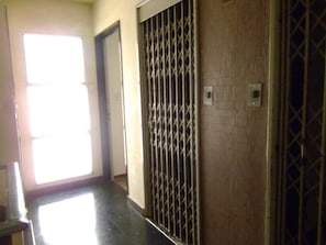 A hallway with a metal gate, a door, and a light source from a window. - Spacious Apartment in Prime Recoleta (Buenos Aires)