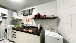 A compact kitchen with a washing machine, a coffee maker, and a microwave. - Jungle Chic in Palermo · Vibrant & Unique (Buenos Aires)