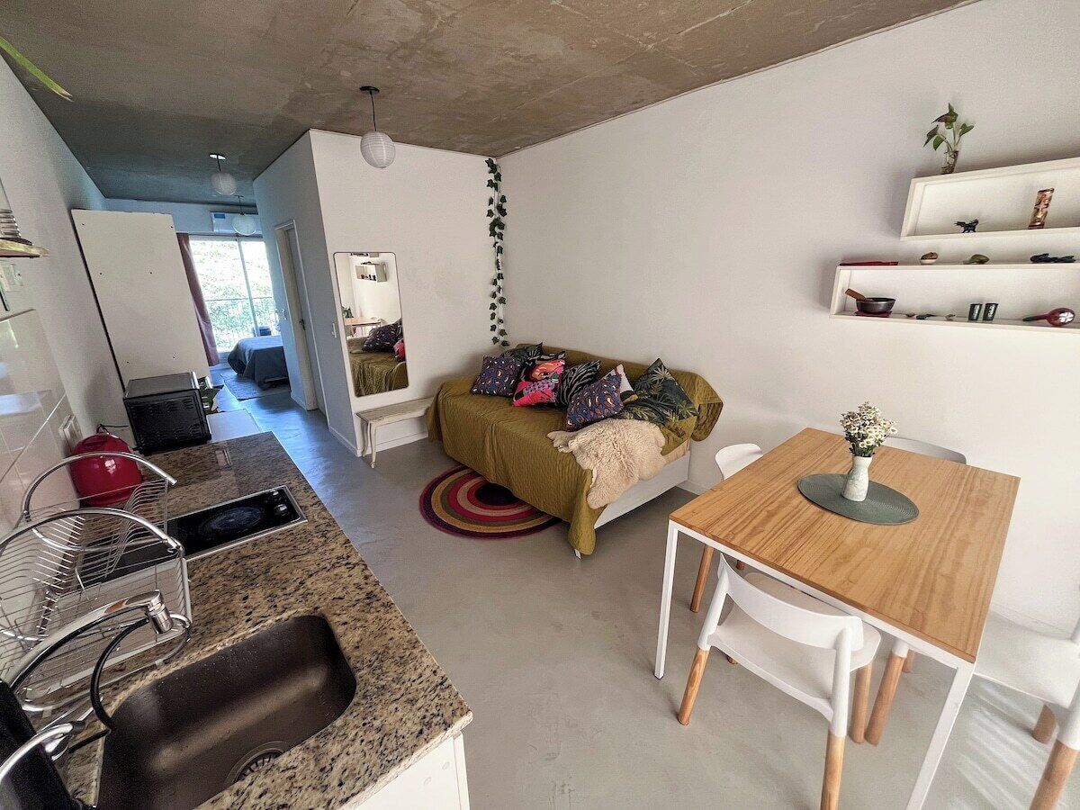 A compact living space with a kitchenette, a dining area, and a sofa.
