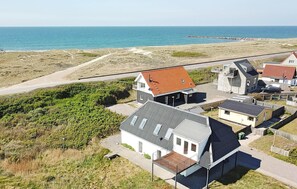 Una zona residencial costera con casas, una playa y una carretera.
