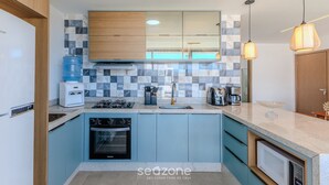 A modern kitchen with a built-in oven, a coffee maker, and a water dispenser. - Apt With Lagoon and Pool View Vll0101 (Maraú)