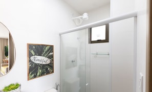 A bathroom with a glass shower enclosure, a framed thank you sign, a mirror, and a marble sink. - Apt With Lagoon and Pool View Vll0101 (Maraú)
