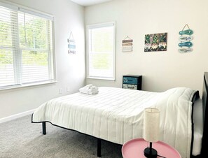 A bedroom with a bed, a bedside lamp, and wall decorations. - 3BR/2BA Charleston Home – Minutes to Downtown & Folly Beach! (Charleston)