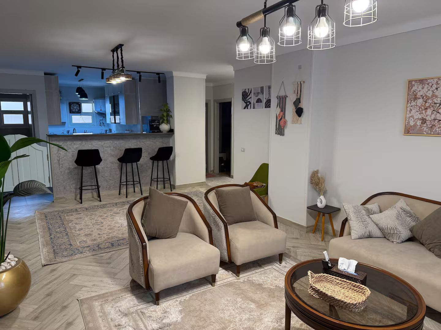 Un salon moderne avec deux canapés, une table basse et une cuisine en arrière-plan.