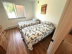 A room with two beds, a window, a painting, and a radiator. - Sterling Riverfront Retreat - Private Kenai River Access (Sterling)