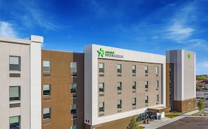 Un edificio moderno di un hotel con tetto piatto, numerose finestre e un logo ben visibile sulla facciata.