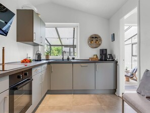 A modern kitchen with a large window, built-in appliances, and a view of the outdoors. - "Soleil" - 1.5km from the sea by Interhome (Skagen)