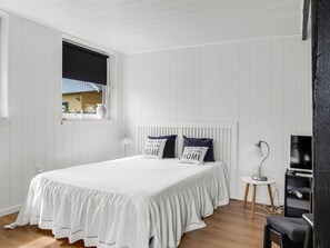 A bedroom with a large bed, a window with blinds, a bedside table, a lamp, and a television. - "Soleil" - 1.5km from the sea by Interhome (Skagen)