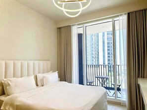 A hotel room with a large bed, a headboard, a balcony with a table and chairs, and a view of buildings. - Discounted Luxury 1Br 4 sleeps Dubai Creek Harbour (Dubai)