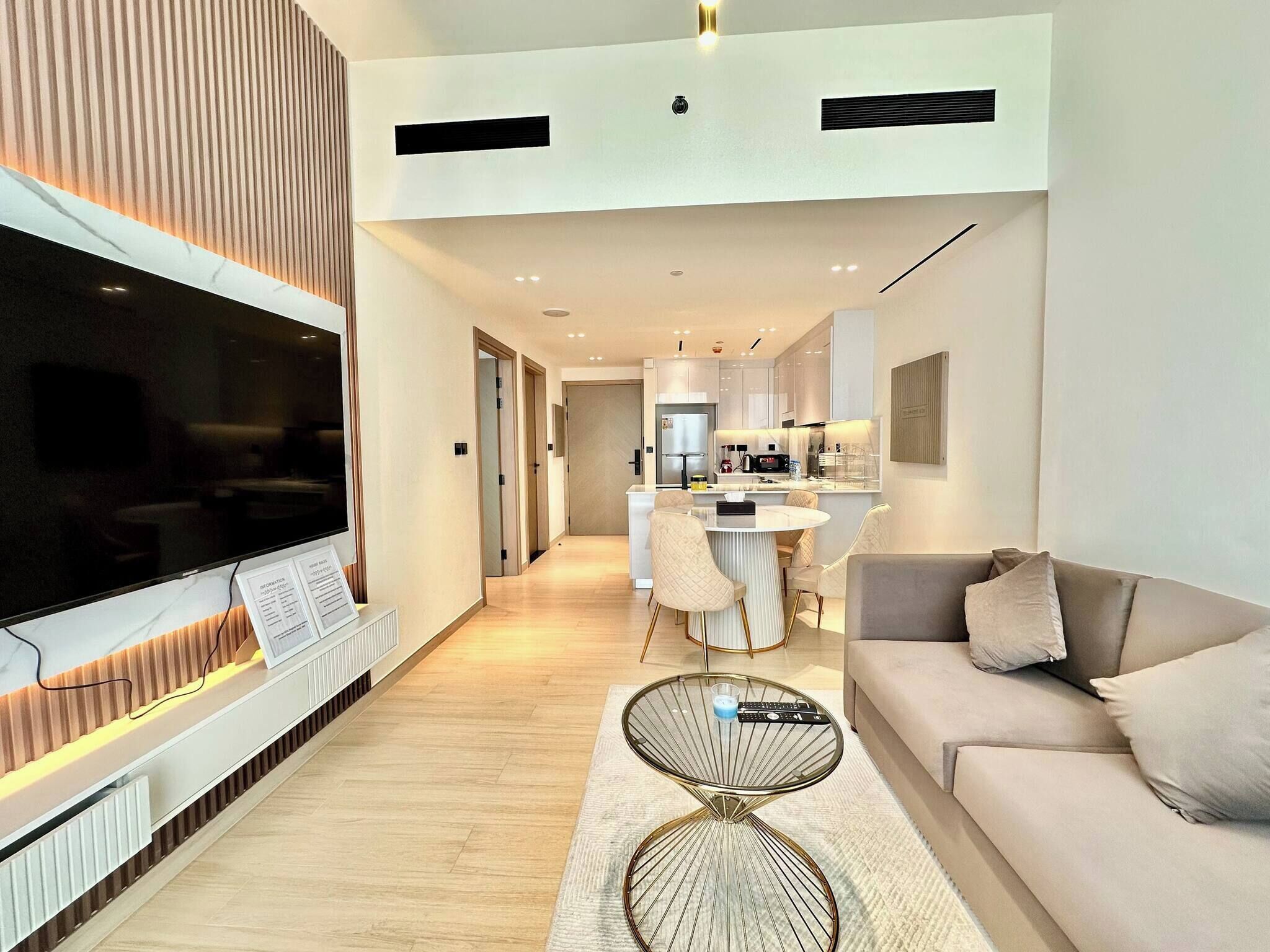 Una sala moderna con un televisor de pantalla plana, un sofá y una mesa de centro.
