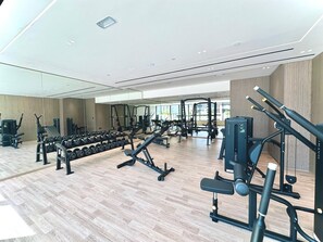 Una gimnàstica moderna amb diversos equips d'exercici, incloent pesos, màquines de pes i màquines cardiovasculars.