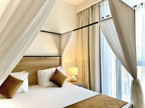 A hotel room with a bed, curtains, a nightstand with a lamp, and a view of the city. - Amazing View Special Discount Luxury 1 Br Apt (Dubai)