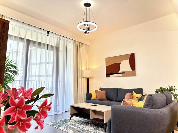 Ein stilvolles Wohnzimmer mit einer Couch, Sesseln, einem Couchtisch und einer Lampe.
