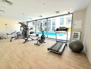 Ein Fitnessraum mit Cardiogeräten, einem Rudergerät und einem Laufband.