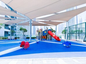 Ein großer Indoor-Spielbereich mit Rutsche, Klettergerüsten und weichen Spielelementen.
