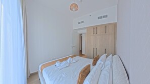 Ett hotellrum med en säng, en garderob och en spegel.