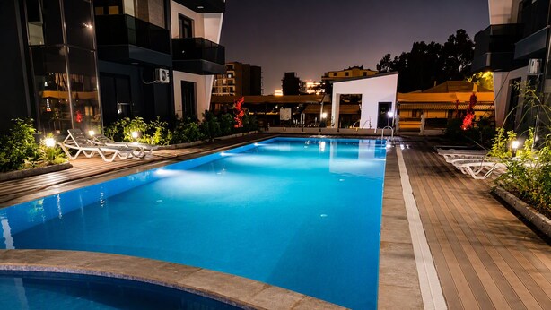 Ein Schwimmbecken mit Liegestühlen und einer Holzterrasse.