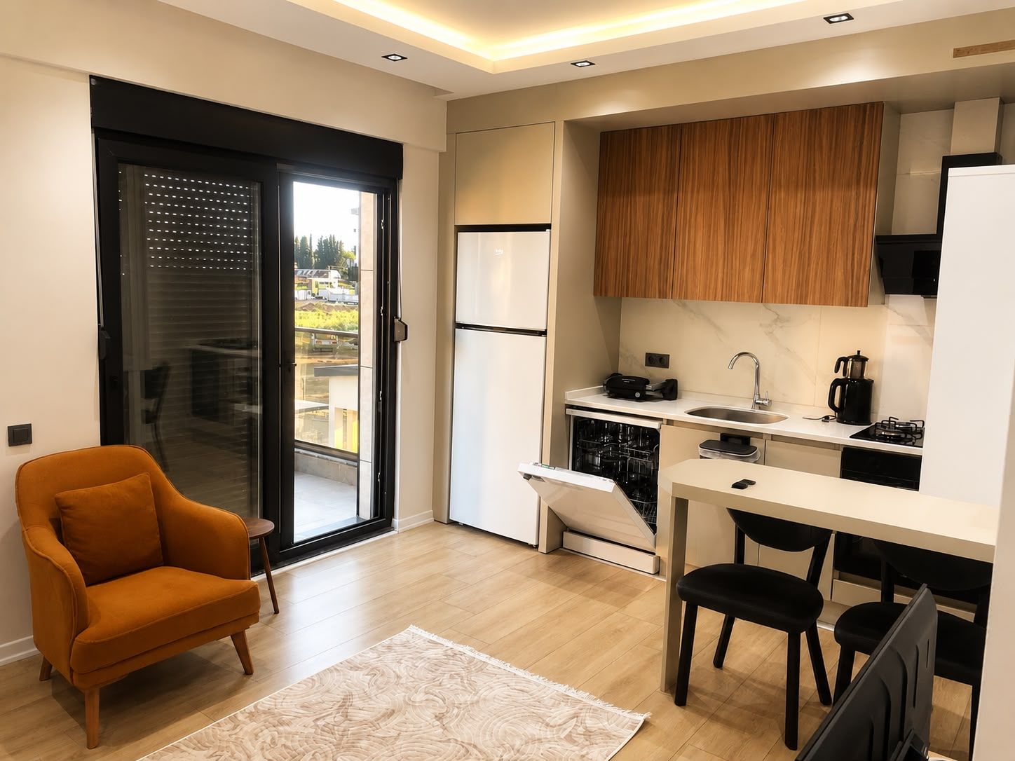 A compact kitchen with a dishwasher, a coffee maker, and a stove.